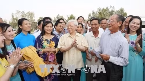 Le SG du PCV Nguyên Phu Trong (au Centre) et les habitants de la commune de My Phu, district de Châu Phu, province d'An Giang. Photo: VNA.