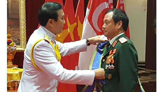 Le général Udomdej Sitabutr, vice-ministre thaïlandais de la Défense, a remis, le 16 mai, l'insigne de chevalier Grand-Croix, première classe au général Phuong Minh Hoa (à droite). Photo: VOV.