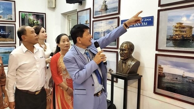 L’artiste photographe Doàn Hoài Trung (au micro) présente ses œuvres lors de l'exposition. Photo : qdnd.vn