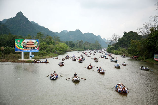 Les visiteurs prennent de petits bateaux le long des voies navigables serpentant entre les falaises de calcaire pour accéder à la pagode des Parfums. Photo : kinhtedothi.vn.