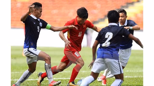 Công Phuong (maillot rouge) a ​réalisé le "coup du chapeau" durant le match ​contre le Cambodge du tournoi de football des SEA Games 29 en Malaisie. Photo: VNA.