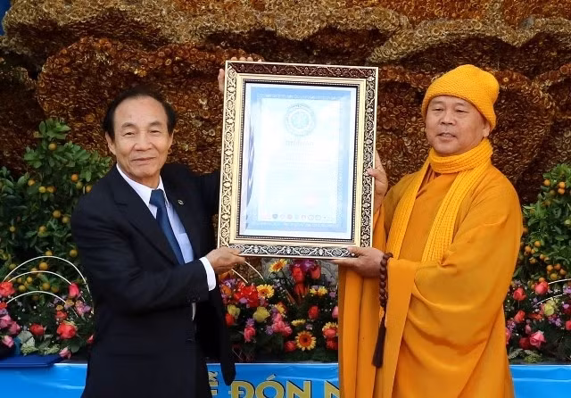 Le représentant de Vietkings remet le certificat reconnaissant le record du monde pour la statuede Bodhisattva Guanyin constituée de fleurs. Photo: NDEL