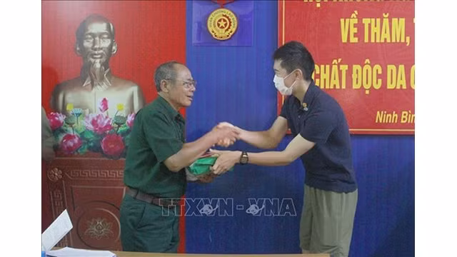 Un représentant de l’Association des Japonais amoureux du Vietnam remet un cadeau à une victime de l’agent orange de la province de Ninh Binh (au Nord). Photo : VNA.