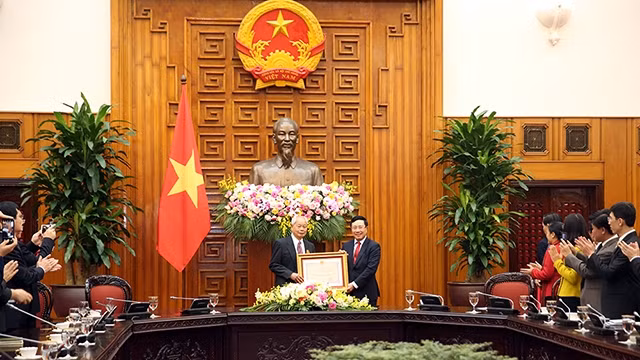 Le Vice-PM Pham Binh Minh remet l'Ordre de l'amitié du Président vietnamien à Huang Qun, ancien fonctionnaire du Département de liaison internationale du Comité central du Parti communiste chinois. Photo : VGP.