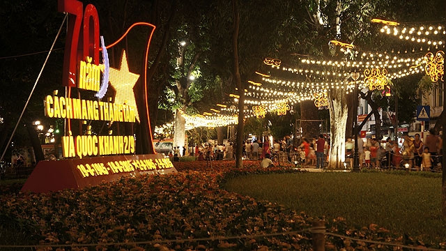 Un panneau de propagande saluant le 70e anniversaire de la Fête nationale illuminé avec la rue de lumière au bord du lac de Hoàn Kiêm - lac de l’Épée restituée.