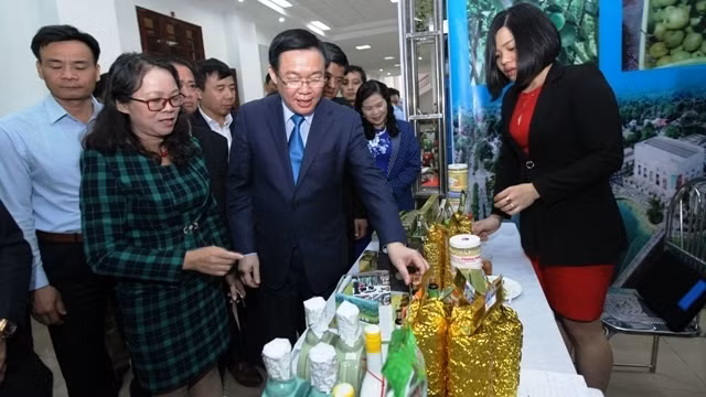  Le Vice-Premier ministre Vuong Dinh Huê en visite dans les stands présentant des produits agricoles typiques des localités. Photo : NDEL.