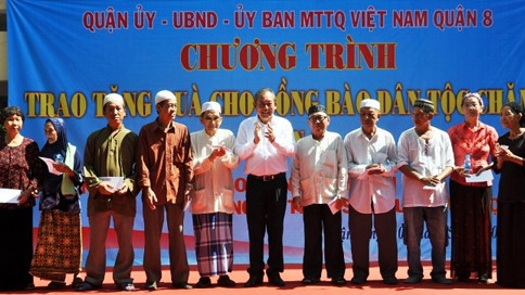 Le vice-premier ministre Truong Hoa Binh (au centre) offre des cadeaux à des Cham du 1er quartier, 8e arrondissement, Hô Chi Minh-Ville. Photo: VGP.