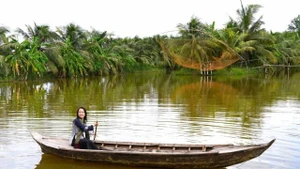 Des visiteurs expérimentent la navigation en pirogue de bois. Photo : vnexpress.net