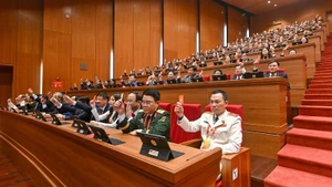 Les délégués votent l’adoption du règlement de fonctionnement du Congrès. Photo : nhandan.vn