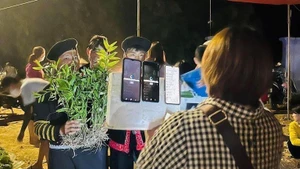 Une vendeuse de la zone montagneuse de Tua Chua vend ses produits en faisant du livestream sur des smartphones. Photo: nhandan.vn