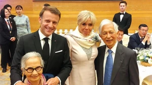 Le couple des professeurs Tran Thanh Van (à droite) et Le Kim Ngoc (à gauche) pose pour une photo avec le président de la République française et son épouse lors d’un dîner de réception à Hanoï, à l’occasion de la visite officielle du président en Vietnam. Photo : ICISE. 