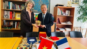 La Dre Florence Veber, directrice de la coopération internationale de l’AP-HP, échange et le Professeur, docteur Le Ngoc Thanh (à droite). Photo : nhandan.vn