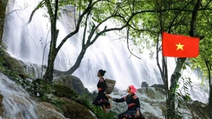 Des jeune filles Thaï posent avec grâce au bord de la cascade Reu. Photo: nhandan.vn 
