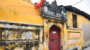 Le portail d’une maison datée de 1929, couvert de mousse et marqué par les fissures du temps, nécessite des mesures de relevé, de consolidation et une protection efficace contre l’humidité. Photo : hanoimoi.vn