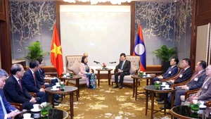 Bui Thi Minh Hoai, membre du Bureau politique et présidente du Comité central (CC) du Front de la Patrie du Vietnam (FPV) (gauche) et le secrétaire général du Parti populaire révolutionnaire lao (PPRL) et président lao, Thongloun Sisoulith. Photo: VNA