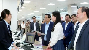 Le Premier ministre Pham Minh Chinh (en chemise bleue) visite le Centre de services administratifs publics de Quang Ninh. Photo: VNA