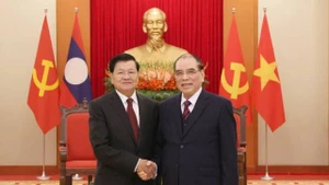 L’ancien secrétaire général du Parti Nong Duc Manh (droite) et le dirigeant lao Thongloun Sisoulith. Photo: VNA