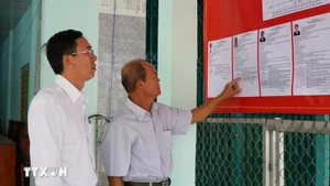 Des électeurs consultent les brèves biographies des candidats au Conseil populaire de la commune de Tan Hong, province de Dong Thap, mandat 2026-2031. Photo : VNA.