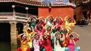 Mme Mai et son groupe d’amies prennent des photos au site patrimonial du Pont japonais. Photo : tienphong.vn