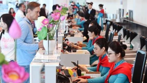 Les comptoirs d’enregistrement de Vietnam Airlines décorés aux couleurs rouge et or du drapeau national. Photo : baoxaydung.vn