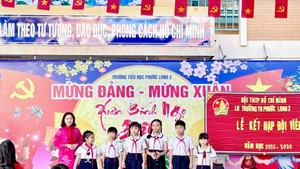La directrice de l’école primaire Phuoc Long 2 et les élèves lors de la cérémonie d’adhésion à l’Organisation des Jeunes Pionniers. Photo : qdnd.vn