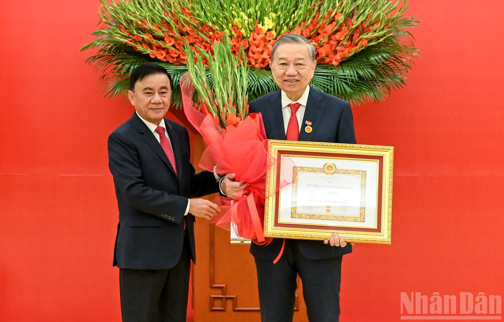 Le permanent du Secrétariat, Tran Cam Tu, remet l’insigne des 45 ans d’adhésion au Parti au secrétaire général Tô Lâm. Photo : NDEL.