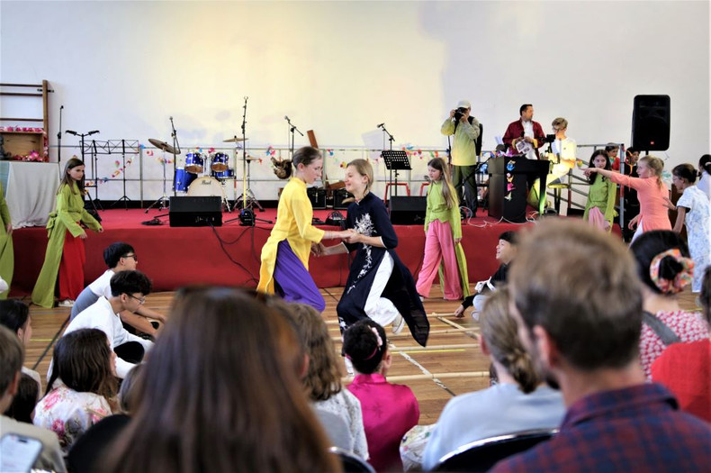 Filles françaises portant le ao dai en faisant la danse de bamboo.