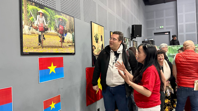 Visiteurs à l'exposition photographique "Vietnam : 50 ans d'unification et de développement". Photo: VNA.