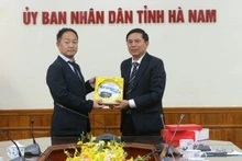 Le vice-président du Comité populaire provincial, Tran Xuan Duong (droite), présente un cadeau au directeur du Bureau du maire de la ville d'Izumiotsu de la préfecture d'Osaka au Japon. Photo : VNA