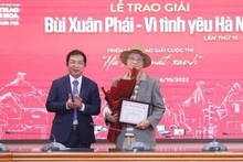 Le directeur général adjoint de l'Agence vietnamienne d'Information Nguyên Tuân Hung remet le Grand Prix au réalisateur Trân Van Thuy (droite). Photo : VNA