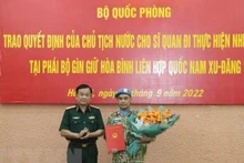 Le général de corps d'armée Hoàng Xuân Chiên (à gauche) remet la décision du président de la République au commandant Bui Van Nhung. Photo : VNA.
