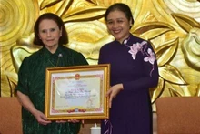 La présidente de l'Union des organisations d'amitié du Vietnam, Nguyen Phuong Nga (droite), remet le satisfecit à Mme Poldi María Sosa Schmidt, présidente de l'Institut culturel Argentine - Vietnam. Photo: VNA