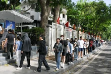De nombreux jeunes font patiemment la queue pour recevoir le supplément spécial du Journal Nhân Dân
