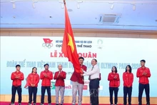 Le ministre de la Culture, des Sports et du Tourisme, Nguyen Van Hung (droite), remet le drapeau symbolisant la détermination à concourir au chef de la délégation vietnamienne aux JO de Paris 2024, Dang Ha Viet. Photo : VNA.