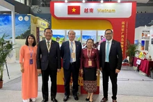 Le consul général Vu Viet Anh prend des photos avec la délégation d’entreprises vietnamiennes et les visiteurs du stand du Vietnam. Photo : baoquocte.