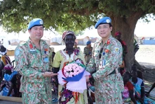 Des représentants de l’hôpital de campagne de niveau, 2 N° 4 offrent des fleurs à une Sud-Soudanaise à l’occasion de la Journée internationale des femmes. Photo : VNA. 