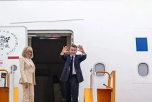 Le président français Emmanuel Macron et son épouse font adieu au Vietnam avant le décollage de l'avion de l'aéroport de Noi Bai. Photo : dantri.com.vn 