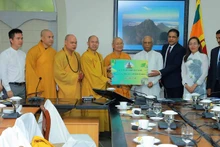 La délégation vietnamienne remet une somme symbolique de 20 000 dollars au Premier ministre sri-lankais. Photo : baoquocte.vn