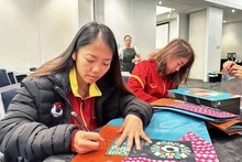 La capitaine Huynh Nhu signe sur le drapeau de l'équipe vietnamienne. Photo : VNA.