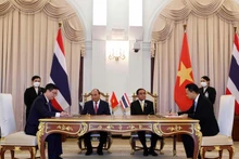 Les représentants de Vietcombank et d'Eximbank signent l'accord de coopération en présence du Président vietnamien, Nguyên Xuân Phuc, et du Premier ministre thaïlandais, Prayuth Chan-ocha. Photo : VNA.