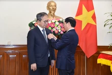 Le ministre vietnamien des Affaires étrangères Bui Thanh Son (droite) remet le 8 mai à Hanoï l’Insigne "Pour la cause de la diplomatie vietnamienne" à l'ambassadeur du Japon au Vietnam, Yamada Takio. Photo : VNA.