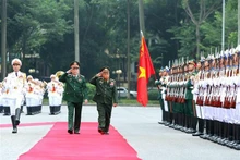 Le chef du Département général de la politique de l’Armée populaire du Vietnam, Luong Cuong, et son homologue lao Thongloi Silivong passent en revue une garde d’honneur. Photo : VNA