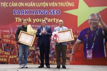 Le ministre de la Culture, des Sports et du Tourisme, Nguyên Van Hùng, remet les certificats de mérite à l’entraîneur Park Hang-seo et son assistant, Lee Young-jin. Photo : VFF.