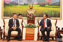 Bounthong Chitmany (à droite), permanent du Secrétariat du Comité central du LPRP et vice-président du Laos, reçoit Le Quoc Minh, rédacteur en chef du journal Nhan dan, vice-président de la Commission de la Propagande et l’Éducation du Comité central du PCV et président de l’Association des journalistes vietnamiens, à Vientiane le 7 juin. Photo : NDEL.
