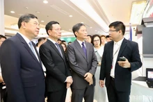 Les dirigeants de la Commission économique du Comité central du Parti, du Ministère de l’Information et des Communications et de la province de Nam Dinh visitent une exposition dans le cadre du forum. 