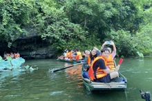 Les jeunes Viêt kiêu sont ravis d’avoir pu faire du kayak et contempler les paysages à Tràng An. Photo : thoidai.com.vn