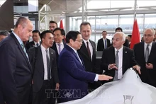  Le Premier ministre Pham Minh Chinh contemple le modèle d'un produit de la la société Turkish Aerospace Industries. Photo : VNA.