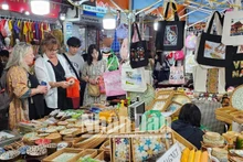 Les touristes étrangers aiment acheter des souvenirs vietnamiens au marché nocturne du vieux quartier de Hanoï. 