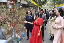 L'épouse du Président Vo Van Thuong, Phan Thi Thanh Tâm, et Mme Louise Araneta Marcos, épouse du Président philippin Ferdinand Romualdez Marcos Jr, visitent le marché aux fleurs de Hàng Luoc. Photo : VNA.