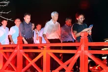 Le Premier ministre singapourien, Lee Hsien Loong, marche sur le pont The Huc. Photo : VNA.